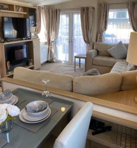 a living room with a couch and a table at Spacious Holiday Home - Romney Sands in Littlestone-on-Sea