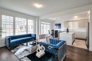 sala de estar con 2 sofás azules y cocina en The Ultimate Staycation, en Bradford