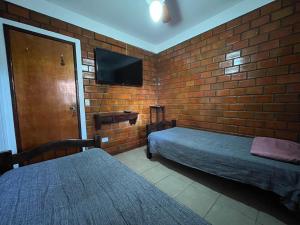 格雷夫森德的住宿－Casa aconchegante e equipada em Gravatá，一间卧室设有两张床和砖墙