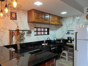 格雷夫森德的住宿－Casa aconchegante e equipada em Gravatá，厨房配有黑色台面和冰箱