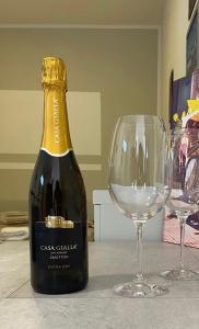 - une bouteille de vin à côté de deux verres à vin dans l'établissement Casa Gialla 89, à Garbagnate Milanese