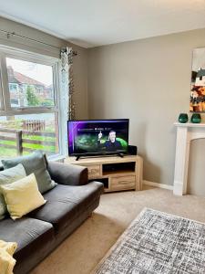 a living room with a couch and a flat screen tv at Canada House - Sleeps 6 -3 King or 6 Single Ideal for contractors in Warrington