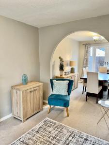 a living room with a blue chair and a table at Canada House - Sleeps 6 -3 King or 6 Single Ideal for contractors in Warrington