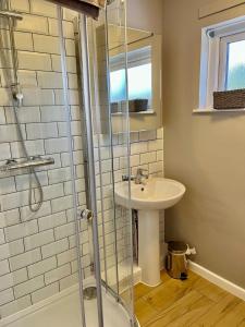 y baño con lavabo y ducha. en Canada House - Sleeps 6 -3 King or 6 Single Ideal for contractors, en Warrington