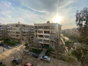 um edifício de apartamentos com carros estacionados num parque de estacionamento em Sunny 2BR Apartment in Maadi no Cairo