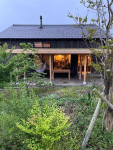 une maison avec une grande fenêtre sur le côté dans l'établissement 菜を｜NAWO, à Goto