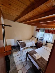 a bedroom with two beds and a wooden ceiling at Nagual -Ecolodge- Airport Shuttle & Restaurant in Tristán Suárez