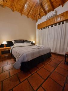 Nagual -Ecolodge- Airport Shuttle & Restaurant في Tristán Suárez: غرفة نوم بسرير كبير وسقف خشبي
