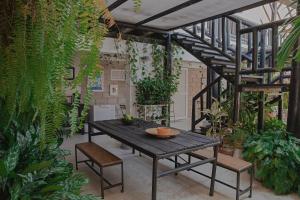 un patio con una mesa de madera y algunas plantas en Casa Ines, en Santa Marta
