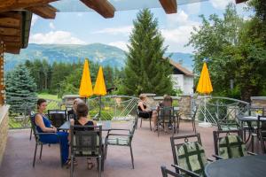 a group of people sitting at tables on a patio at Familiengasthof St. Wolfgang in Spittal an der Drau