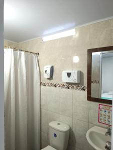 een badkamer met een toilet, een wastafel en een spiegel bij Posada Doña Rosa in San Andrés