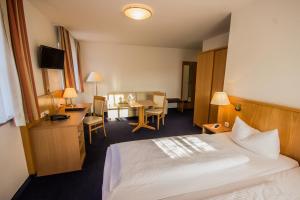 Habitación de hotel con cama y escritorio en IBB Hotel Passau Sued en Passau