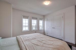 a white bedroom with a large bed with windows at Unwind Here in a Stylish and Cozy Space in Bradford