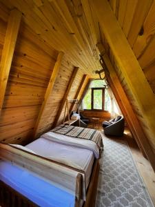 a bed in a room with a wooden ceiling at Serintepe Bungalov in Çamlıhemşin