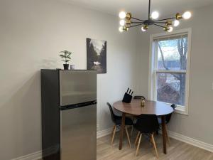 a kitchen with a table and a refrigerator at 3-Bedroom House in Little Italy Downtown-Free Parking in Toronto