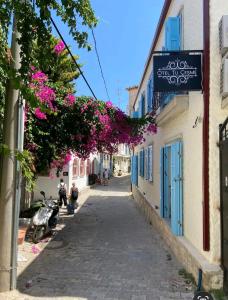 an alley with pink flowers and a sign on a building at Apart TU Çeşme in İzmir