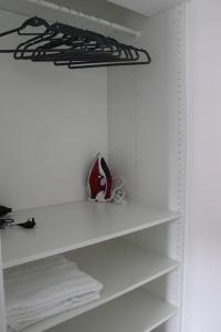 ein Schrank mit weißen Regalen und weißen Handtüchern in der Unterkunft Lovely flat with Wi-Fi and free parking in Reading