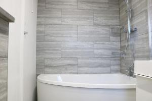 bagno con vasca e servizi igienici bianchi di Lovely flat with Wi-Fi and free parking a Reading