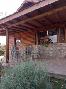 ein Haus mit zwei Stühlen und einem Tisch auf einer Terrasse in der Unterkunft CABAÑAS ALMA SERENA in Capilla del Monte