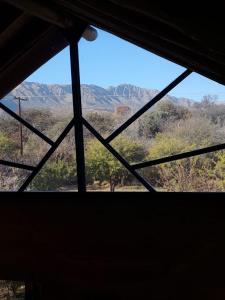 a view of the mountains from a window at CABAÑAS ALMA SERENA in Capilla del Monte