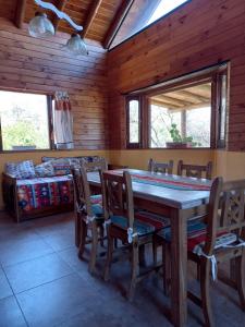 ein Esszimmer mit einem Holztisch und Stühlen in der Unterkunft CABAÑAS ALMA SERENA in Capilla del Monte