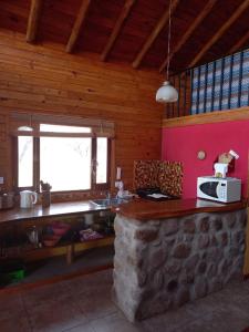 eine Küche mit Theke und Mikrowelle in der Unterkunft CABAÑAS ALMA SERENA in Capilla del Monte