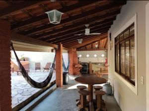 een veranda met een hangmat en een tafel en stoelen bij Um lugar para descansar e relaxar in Serra Negra