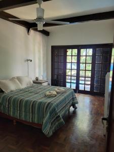 a bedroom with a bed and a ceiling fan at CASA DE TECHO AZUL in Resistencia