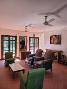 a living room with leather furniture and a ceiling fan at CASA DE TECHO AZUL in Resistencia