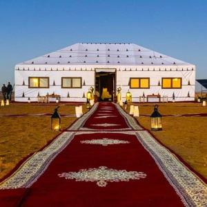 a large white building with a red carpet in front of it at Maria Sahara Camp in Merzouga