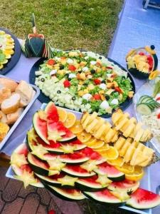 a table topped with plates of fruits and vegetables at Van Buuren Lodge in Germiston
