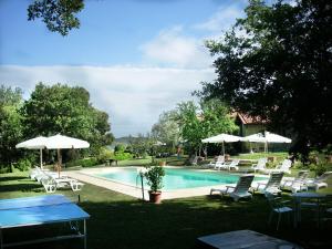 a swimming pool with chairs and tables and umbrellas at Antico Casale Pozzuolo in Seggiano