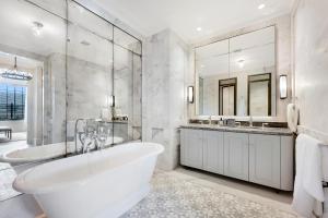 a bathroom with a tub and a large mirror at The California Romantic - Residence 3 in Melbourne