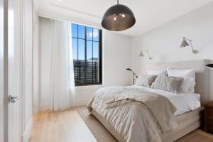 a white bedroom with a bed and a window at The California Romantic - Residence 3 in Melbourne