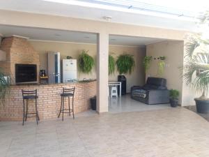 eine Terrasse mit einer Bar mit einem Sofa und einer Küche in der Unterkunft Edicula com um quarto banheiro e piscina e lazer in Foz do Iguaçu