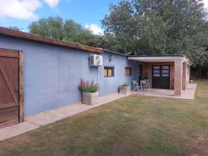 a blue house with a patio and a yard at Cardozo House, casa de campo in Villa Dolores