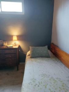 ein Schlafzimmer mit einem Bett, einer Kommode und einem Fenster in der Unterkunft Cardozo House, casa de campo in Villa Dolores