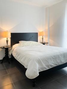 sypialnia z dużym łóżkiem z dwoma lampami na stołach w obiekcie Departamentos Huerta w mieście Ciudad Fernández