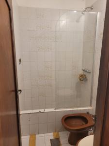 a bathroom with a toilet and a glass shower at CASA DE TECHO AZUL in Resistencia