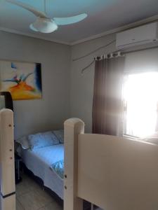 Schlafzimmer mit einem Bett und einem Deckenventilator in der Unterkunft Edicula com um quarto banheiro e piscina e lazer in Foz do Iguaçu