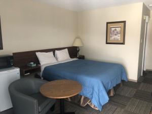 a hotel room with a bed and a table and a chair at Houston Motor Inn in Houston