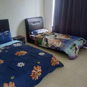 a bedroom with two beds and a blue comforter at Pro-Qaseh Room Stay , Darulaman Lake Home in Jitra