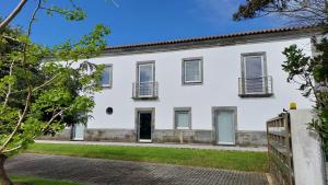 an exterior view of a white house at Retiro das Camélias in Lajes das Flores