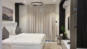 a bedroom with a white bed and a window at Embassy gardens Luxury suites CPG in Accra +173 photos