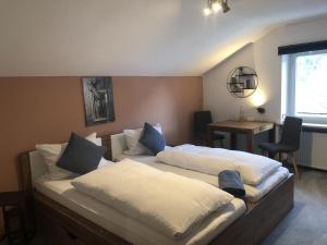 a bedroom with a bed with white sheets and blue pillows at Pension und Ferienwohnung Frech in Marktschellenberg