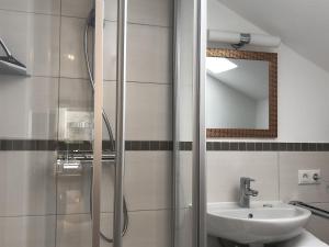 a bathroom with a shower and a sink and a mirror at Pension und Ferienwohnung Frech in Marktschellenberg