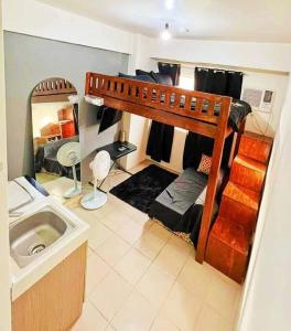 een slaapzaal met een stapelbed en een wastafel bij Studio type Loft bed near Ortigas in Manilla