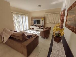 een woonkamer met een bank en een televisie bij Um lugar para descansar e relaxar in Serra Negra