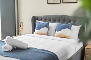 a bedroom with a large bed with blue and white pillows at Olympic Park Stadium Cozy 1 bedroom Apt in Sydney +8 photos