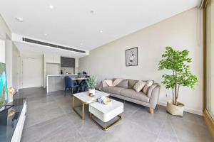 a living room with a couch and a table at Olympic Park Stadium Cozy 1 bedroom Apt in Sydney
